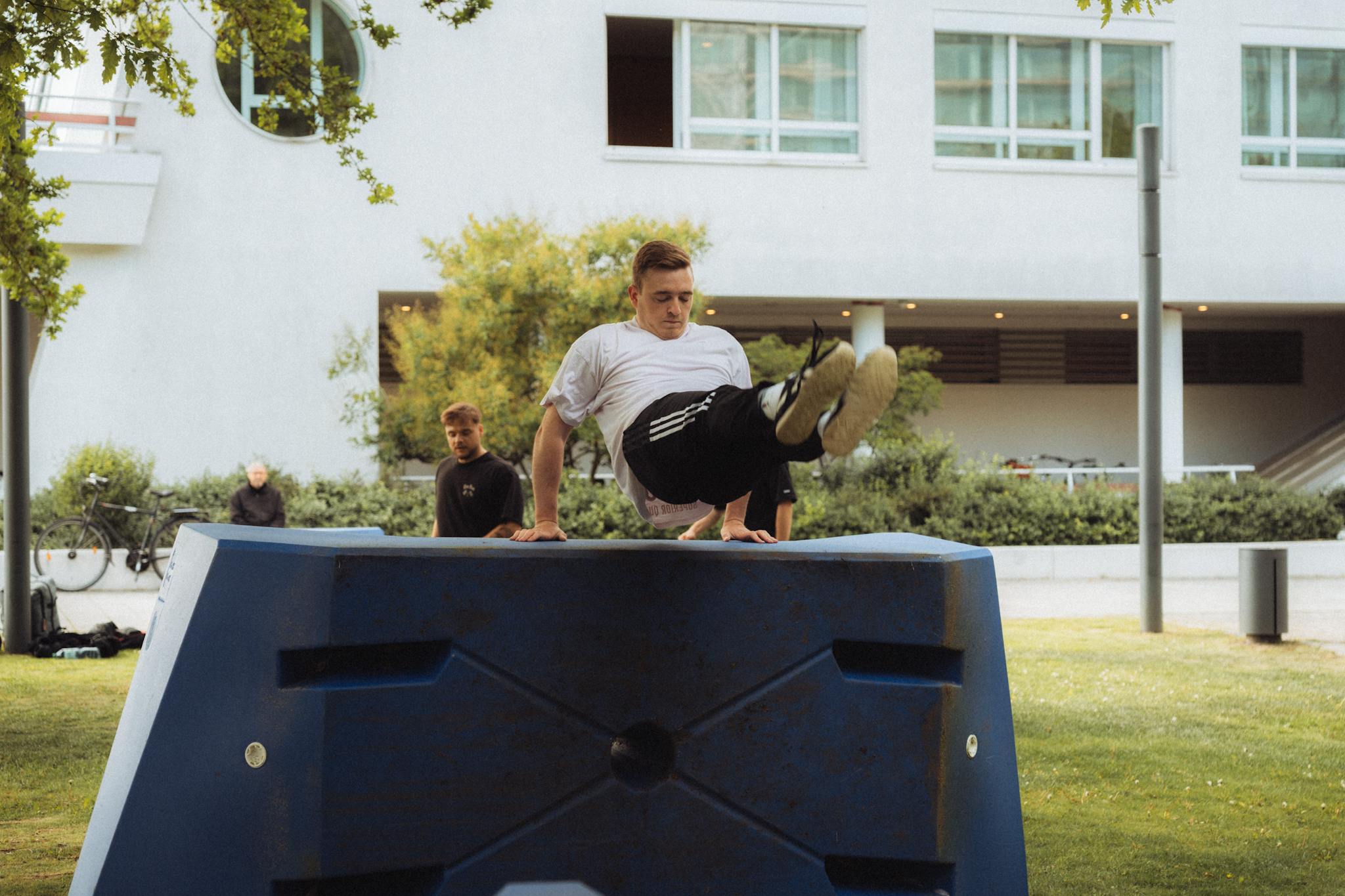 Dynamic parkour action as a man skillfully navigates an urban obstacle.